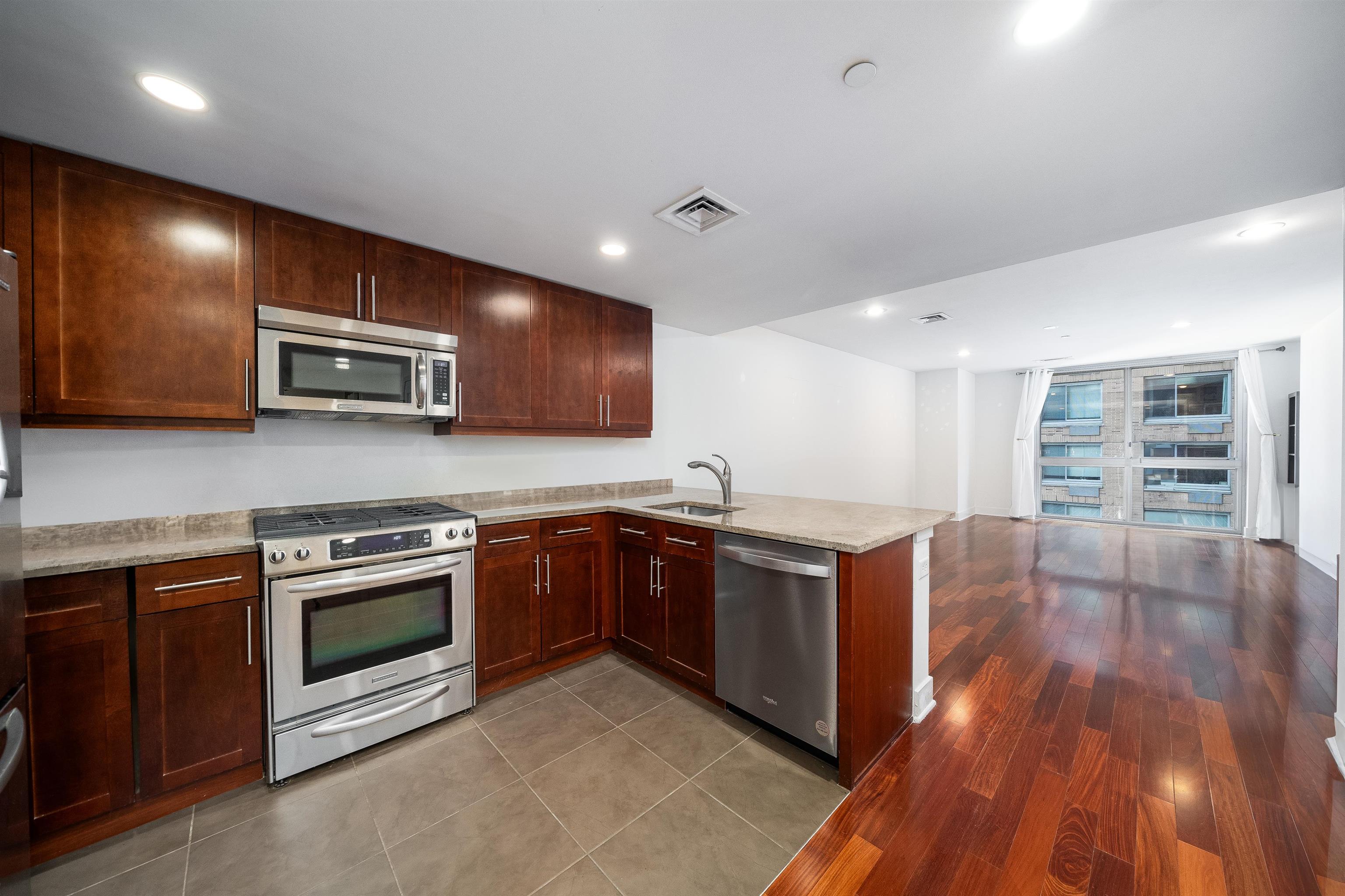 a kitchen with stainless steel appliances granite countertop wooden cabinets and a stove top oven