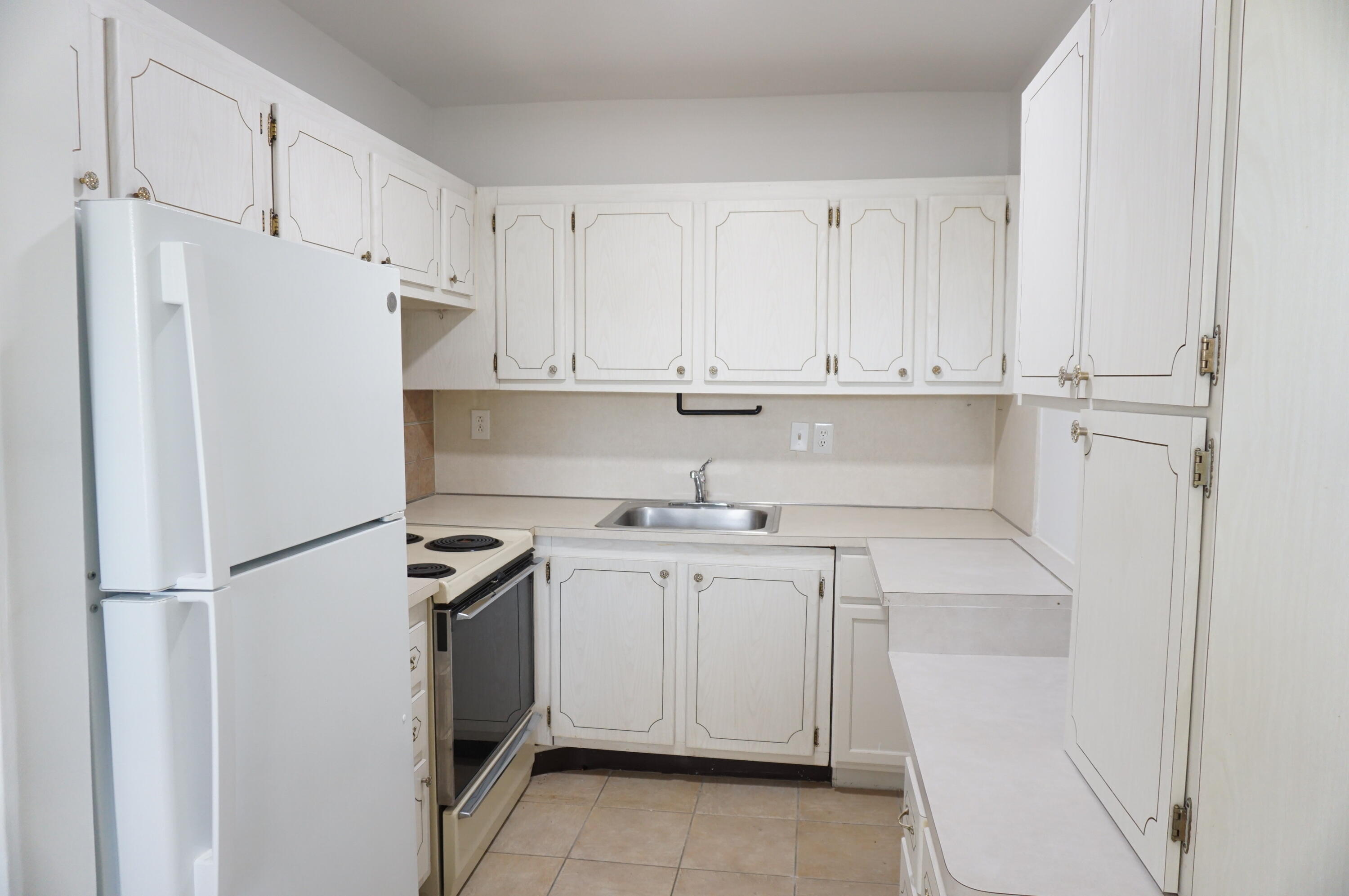 a kitchen with white cabinets and white appliances