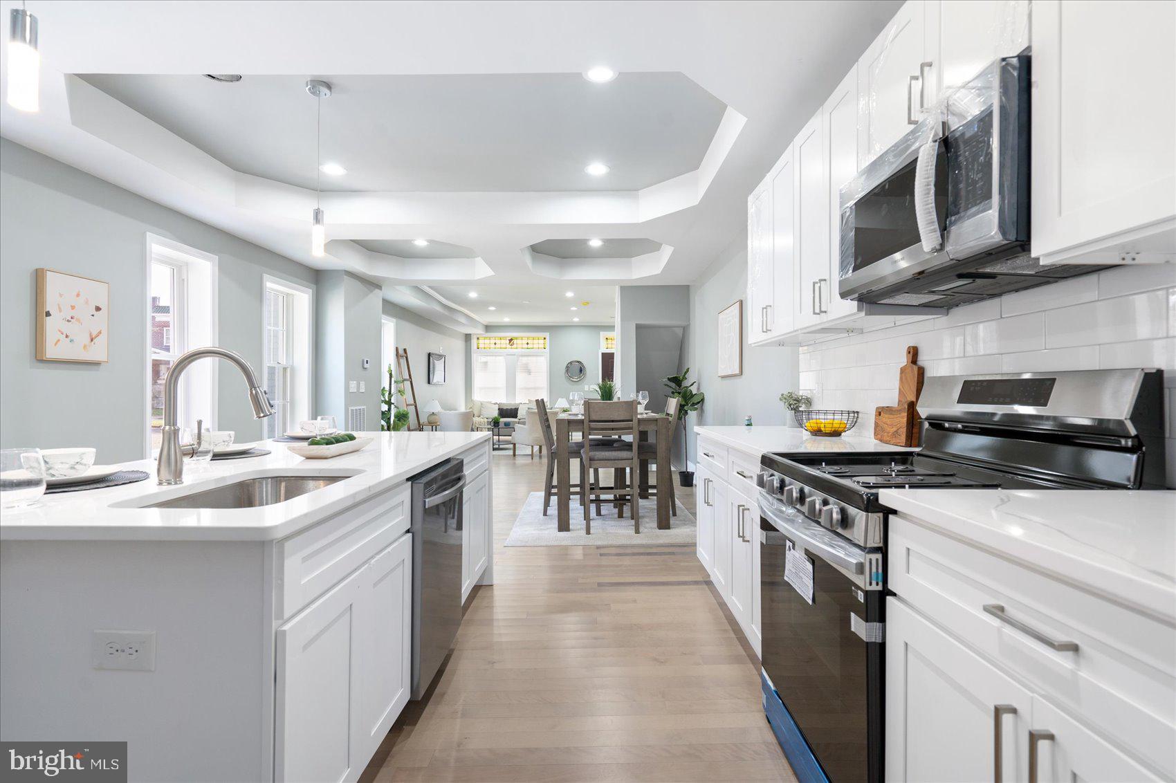 a kitchen with stainless steel appliances granite countertop a sink a stove and a wooden cabinets