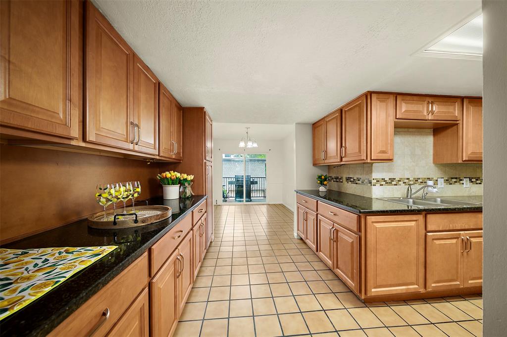 a kitchen with granite countertop a sink stove and cabinets