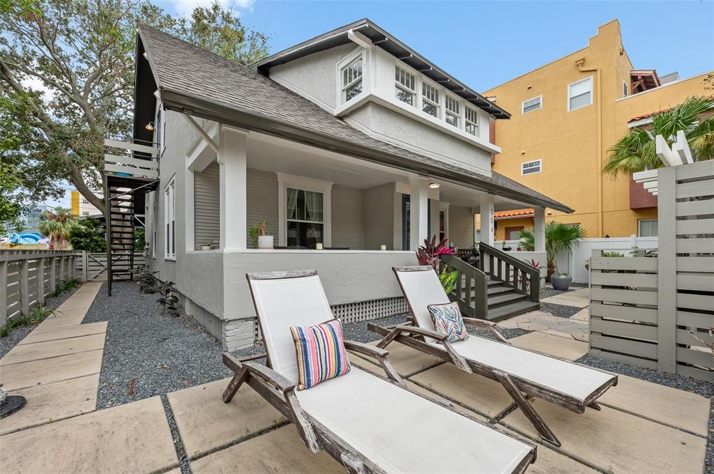 a view of a patio with table and chairs with wooden floor and fence