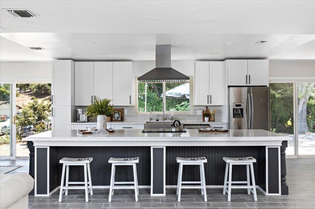 a kitchen with stainless steel appliances kitchen island granite countertop a dining table and chairs