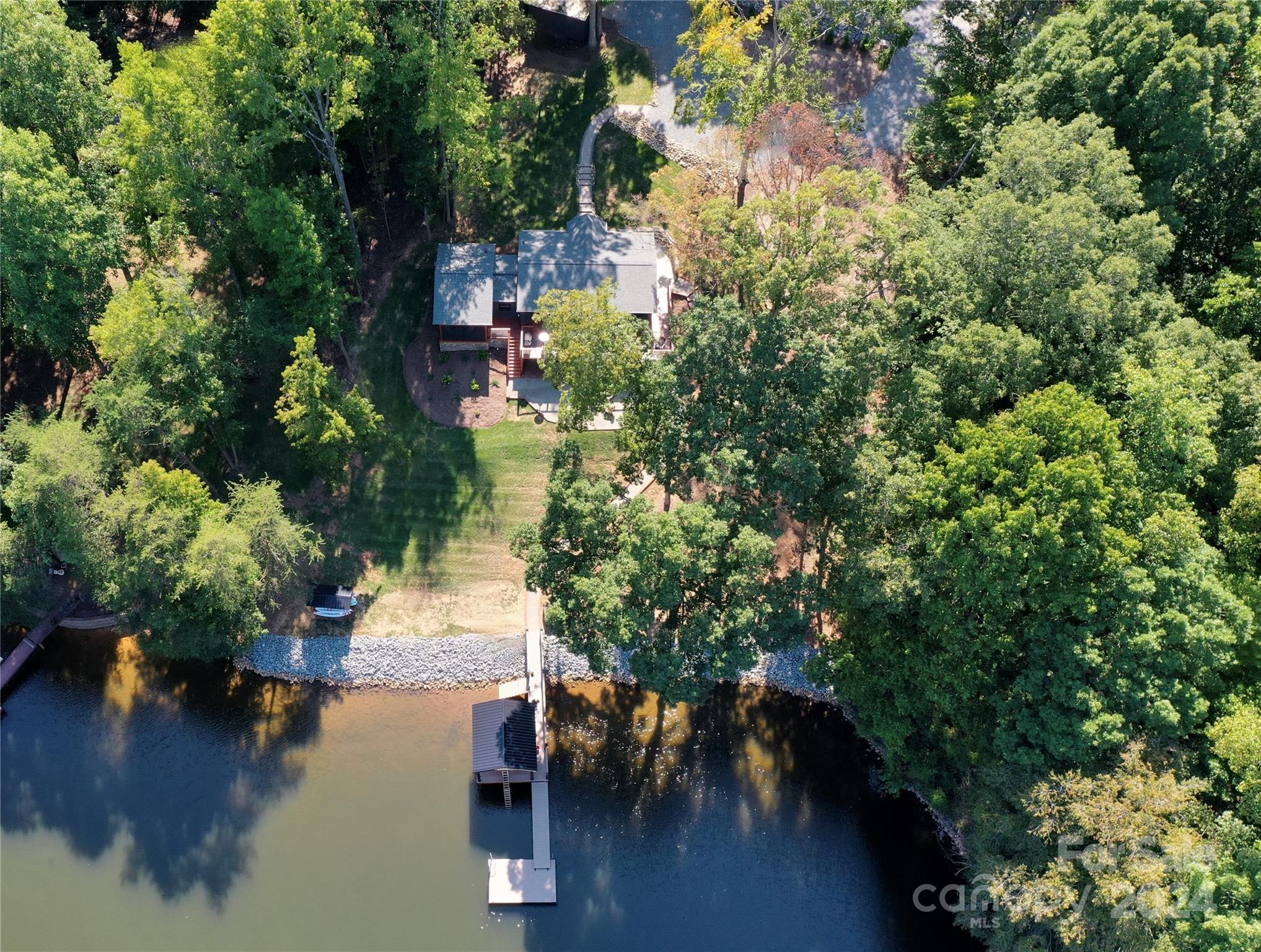 an aerial view of a house with a yard lake house and outdoor seating