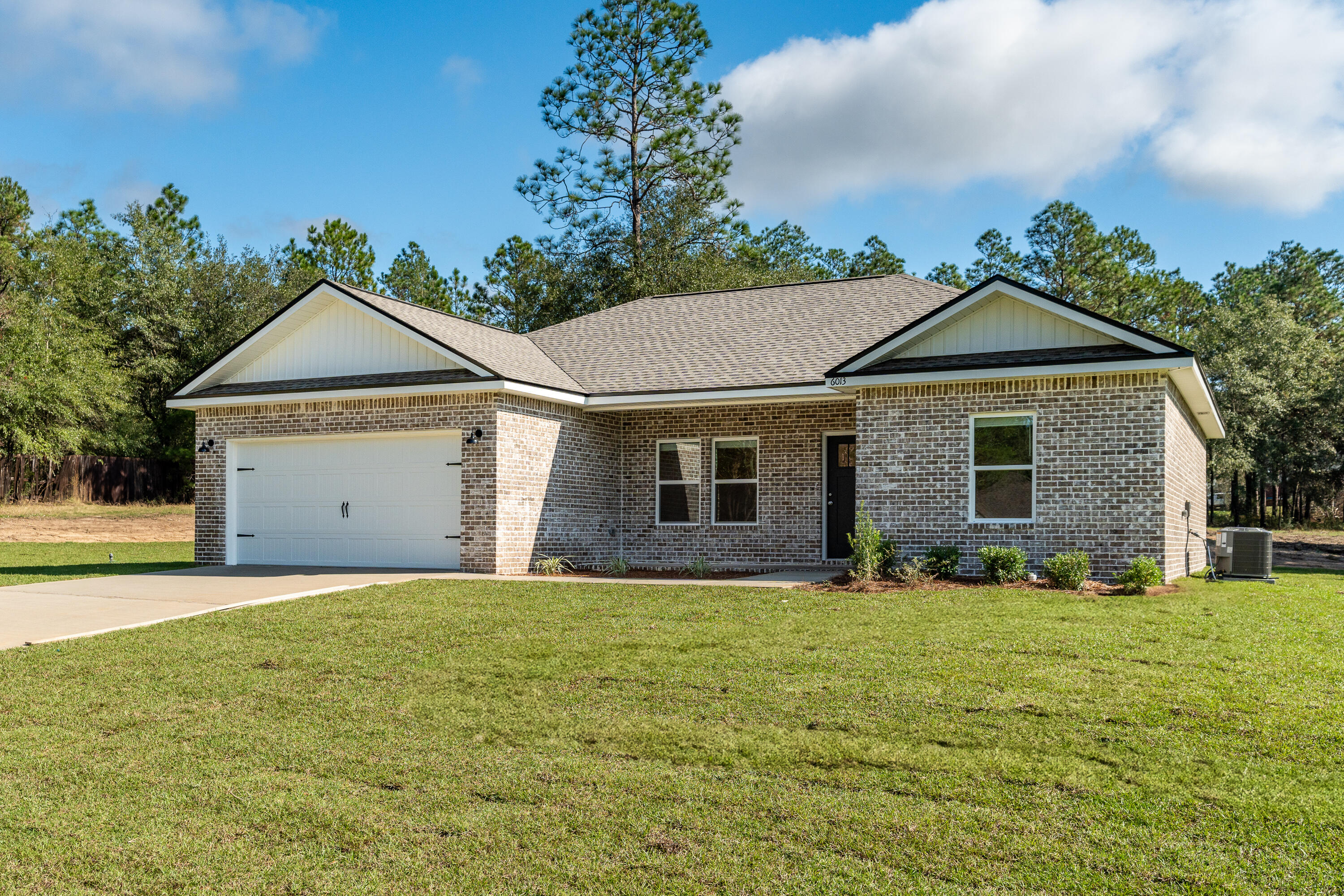 a front view of a house with yard and trees