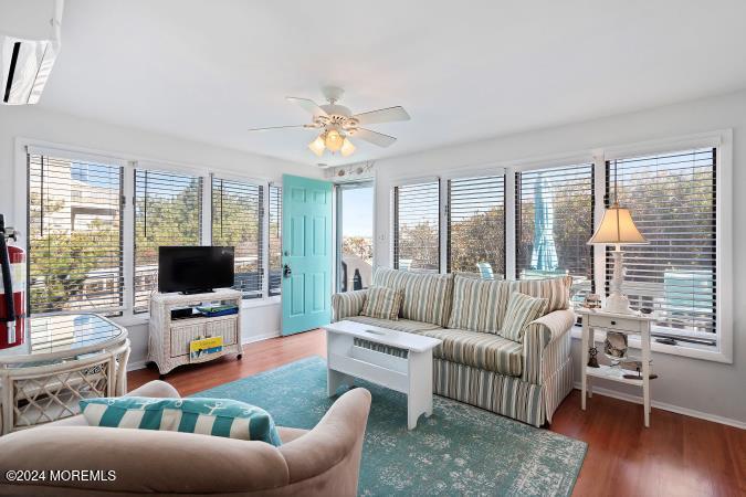 a living room with furniture flat screen tv and a large window