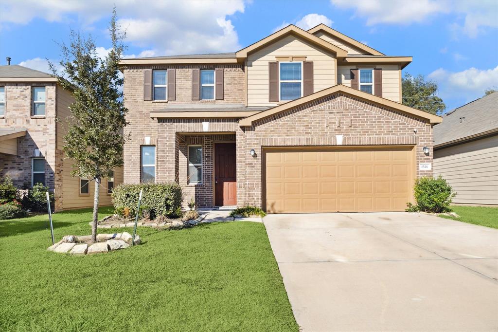 a front view of a house with a yard and garage