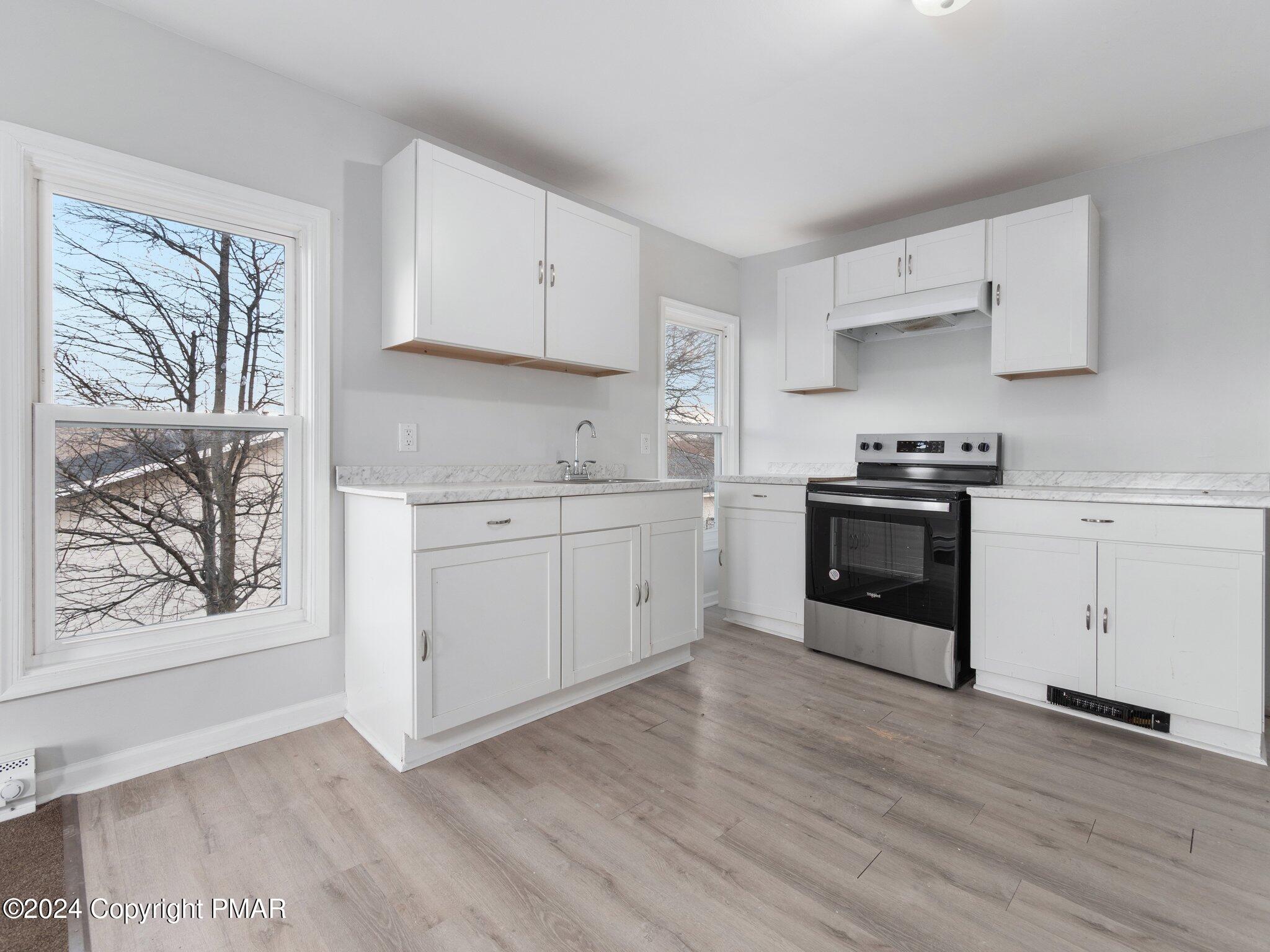 a kitchen with white cabinets and white appliances