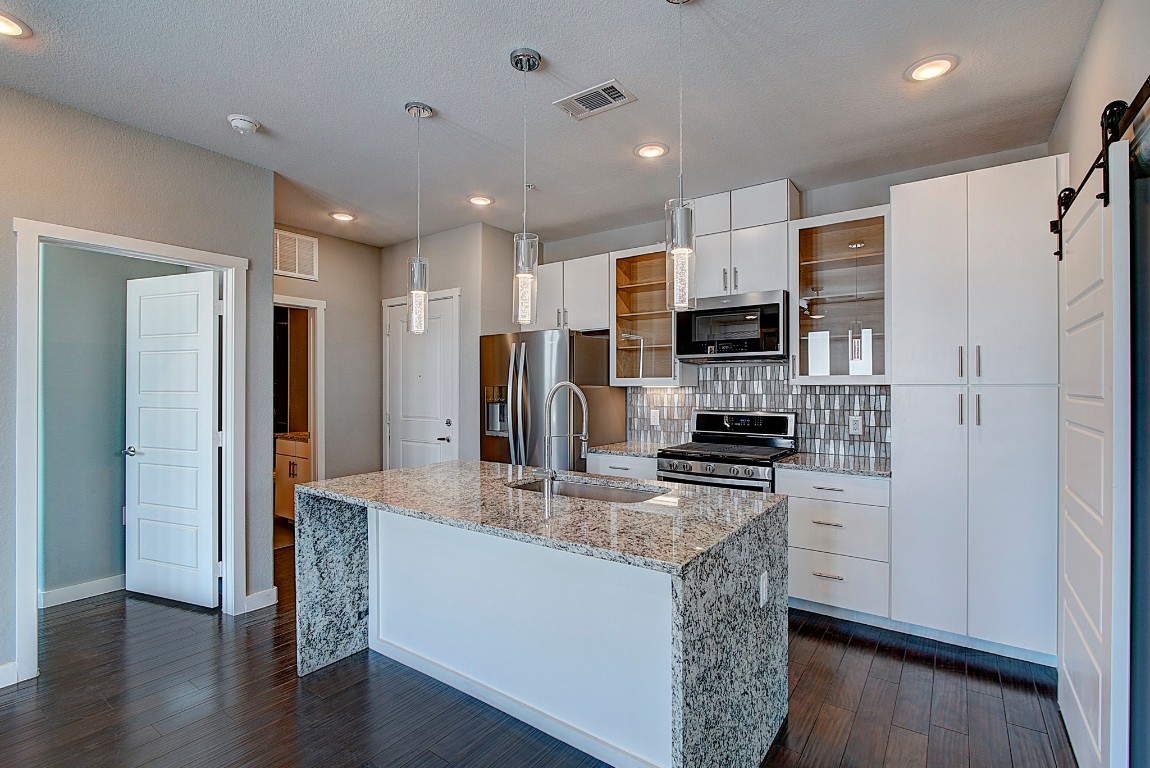 a kitchen with stainless steel appliances granite countertop a refrigerator and a stove