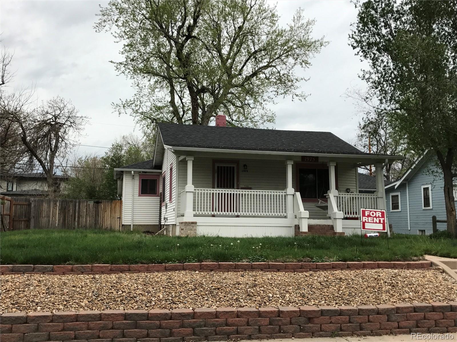 a front view of a house with garage and plants