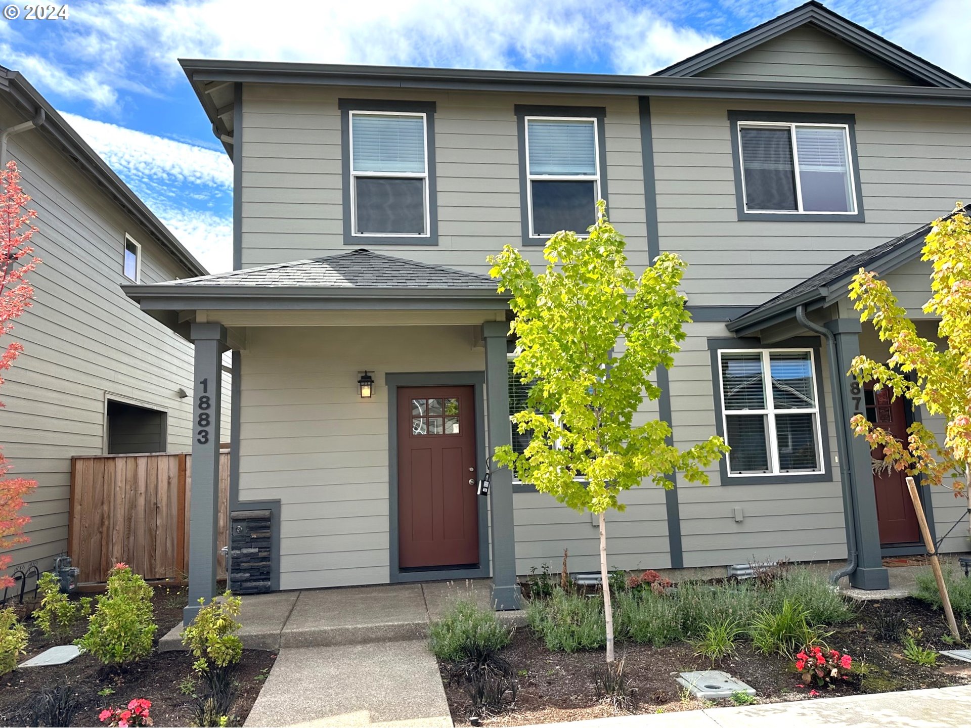 a front view of a house with plants