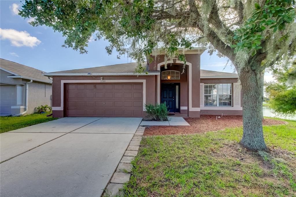 front view of a house with a yard and an trees