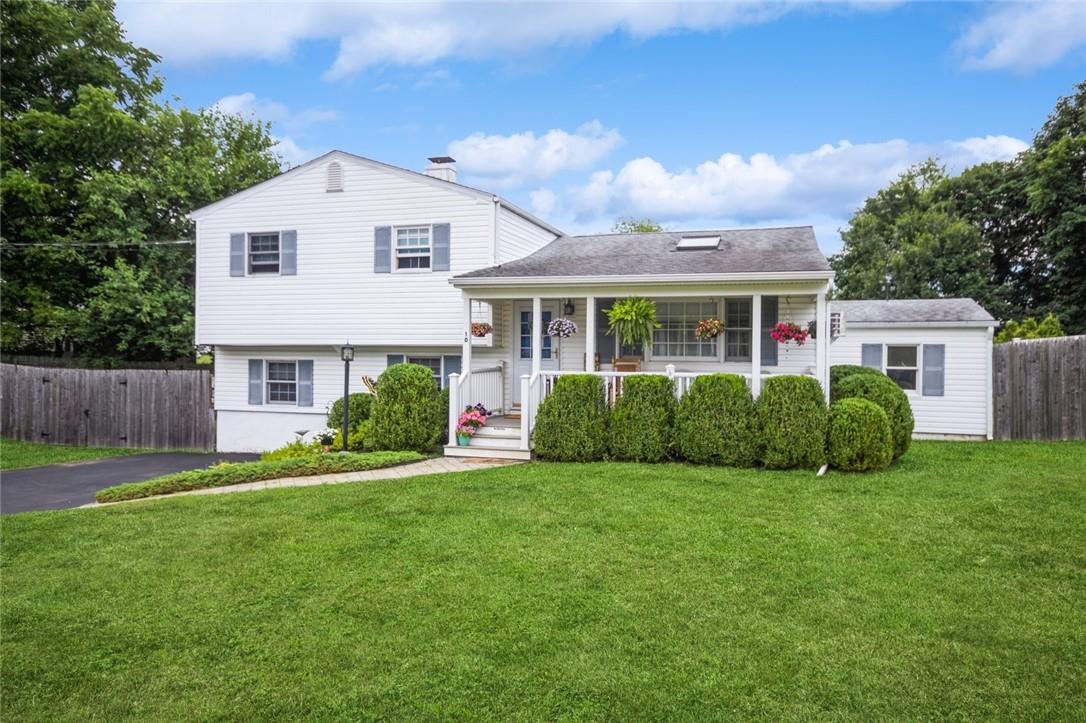 Bi-level home with covered porch and a front yard