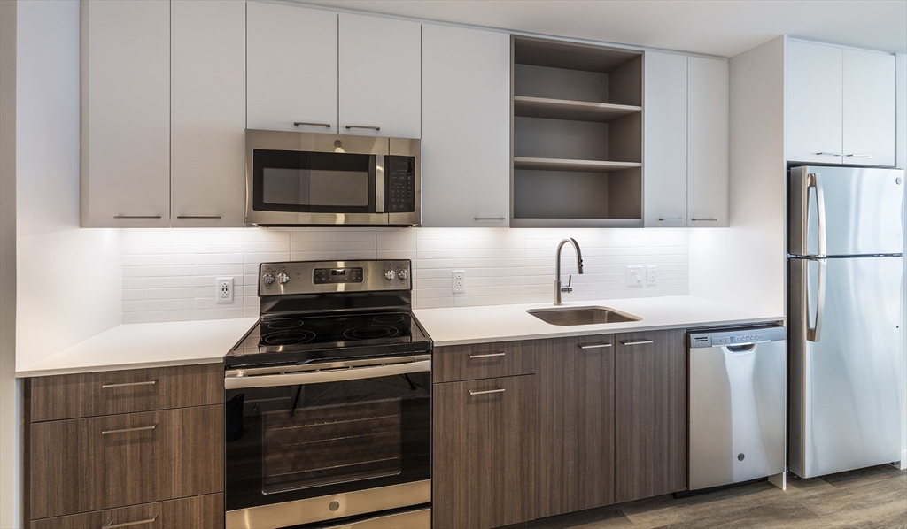 a kitchen with stainless steel appliances a stove sink and microwave