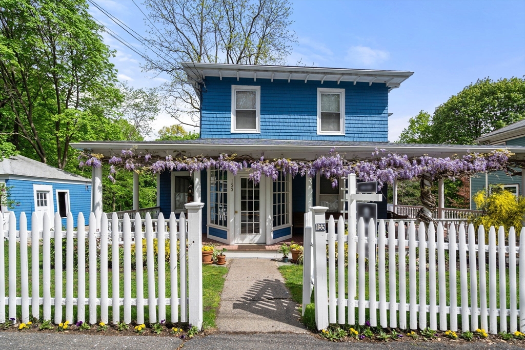 a view of a house with a small yard and wooden fence