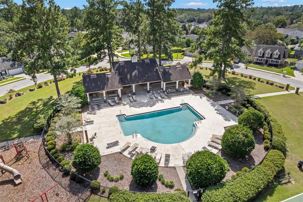 an aerial view of a house with swimming pool and outdoor seating