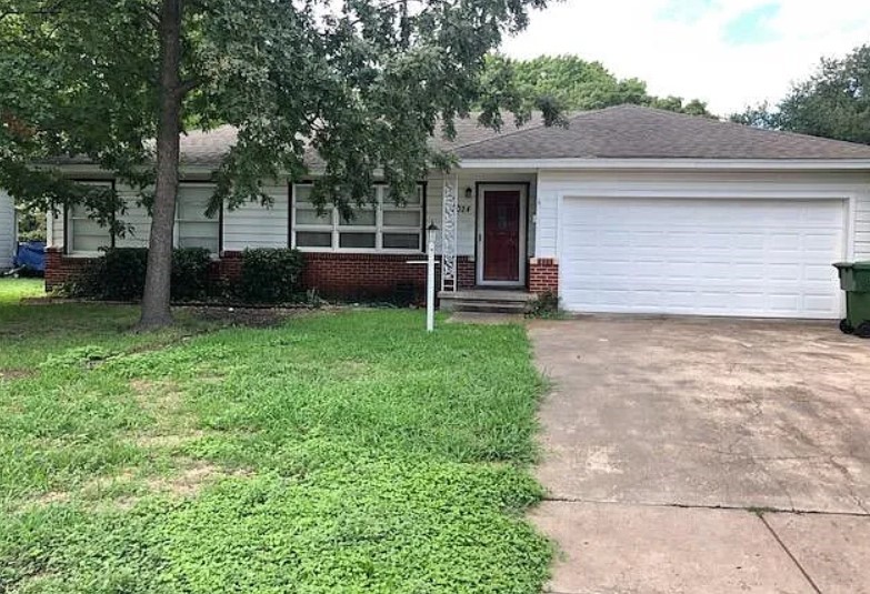 a view of a house with a yard and a large tree