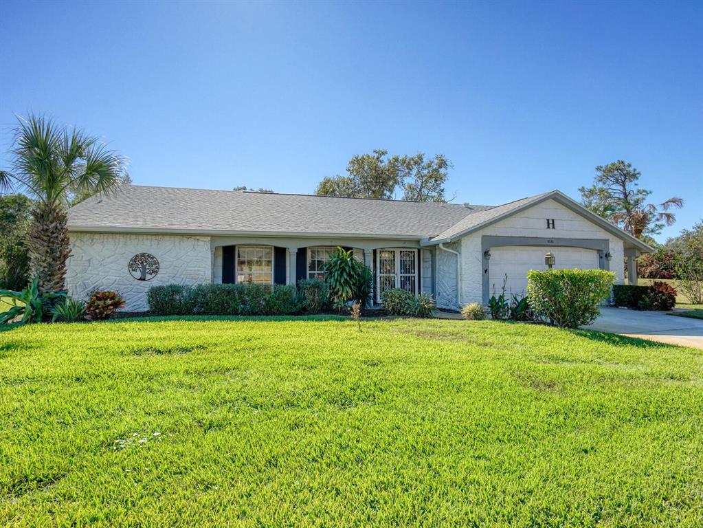 a front view of a house with a yard and trees