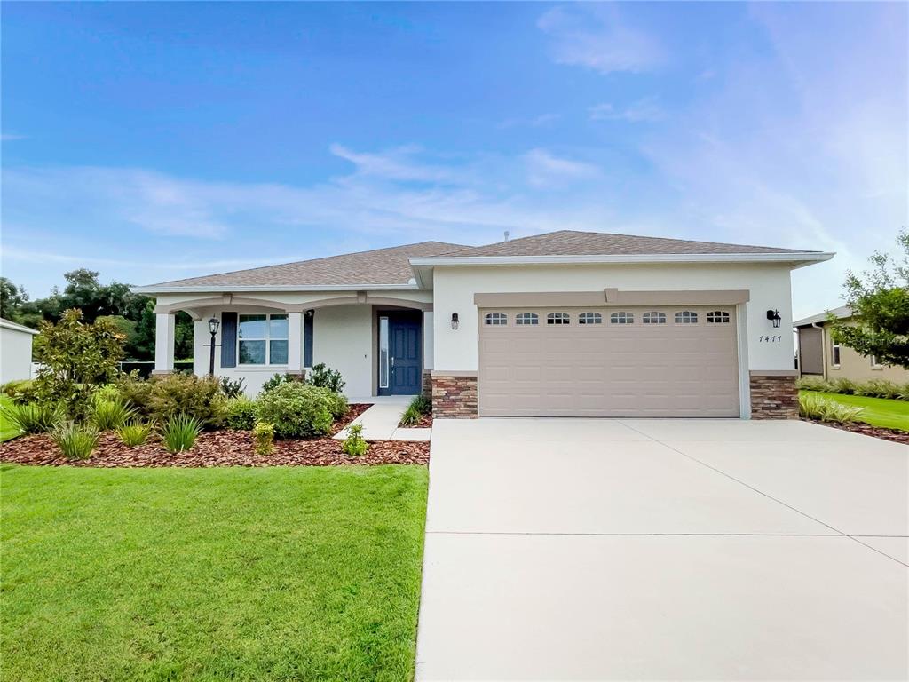 a front view of a house with a yard and garage