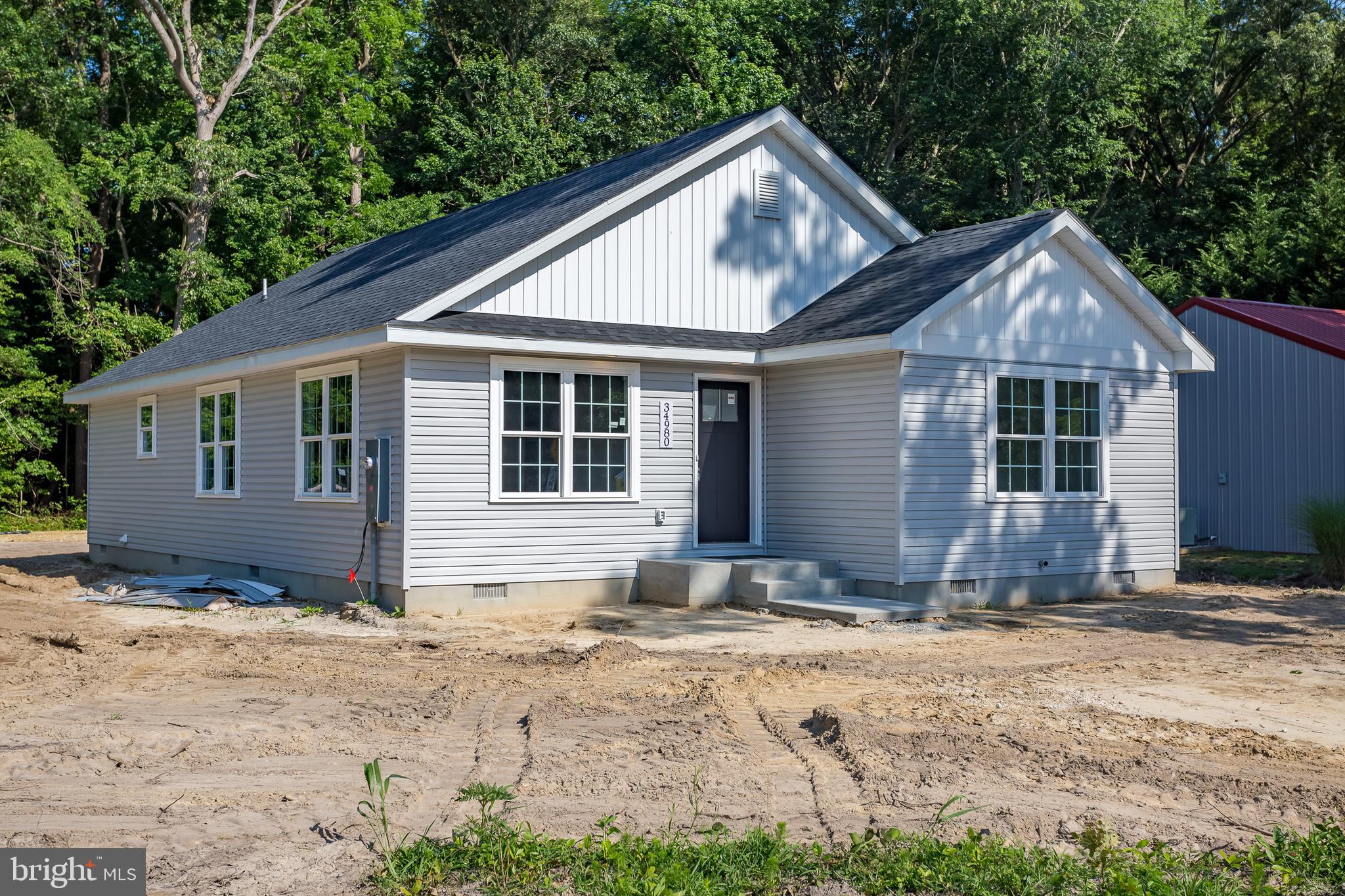 a view of house with yard and sitting area