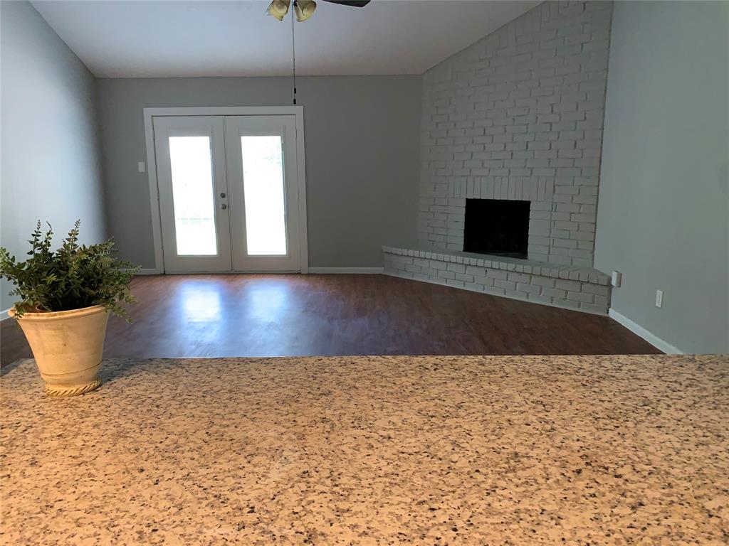 a view of a room with wooden floor and a potted plant