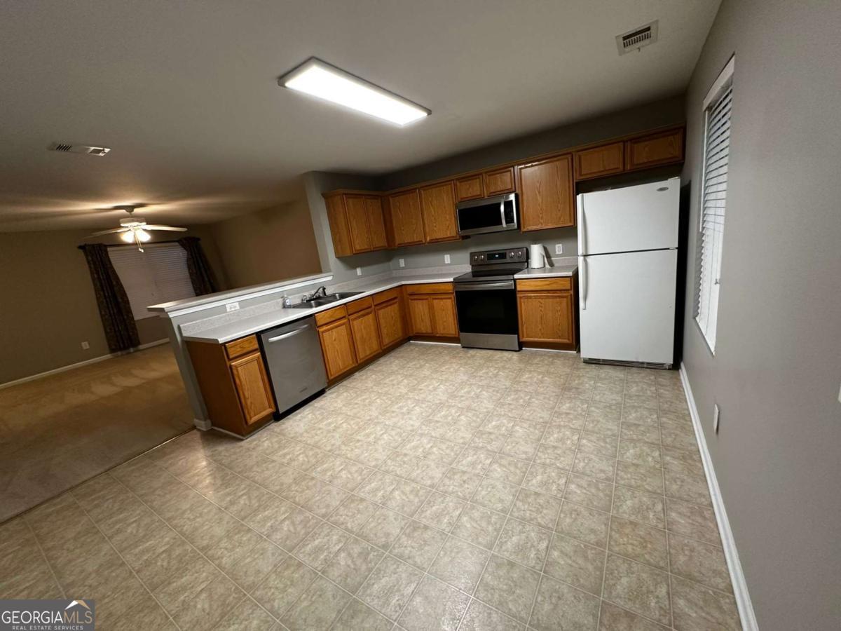 a kitchen with stainless steel appliances granite countertop a refrigerator a stove a sink and a refrigerator