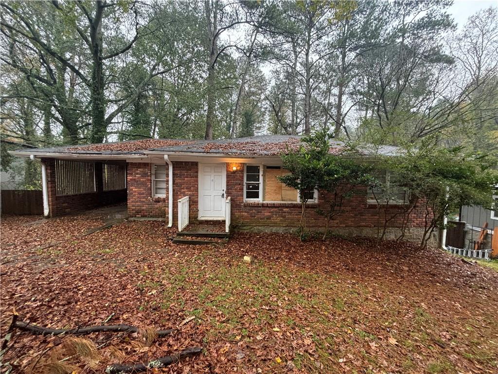 a view of a house with a yard and large trees