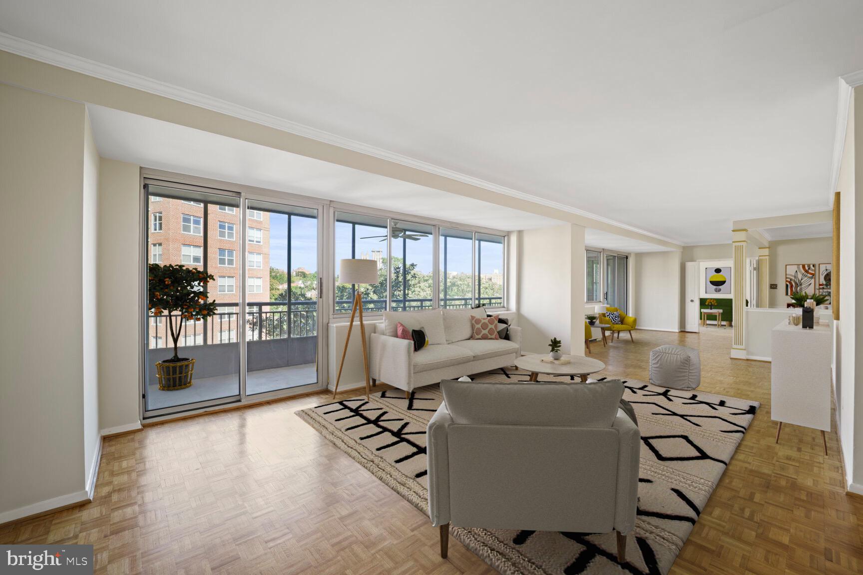 a living room with furniture large windows and wooden floor