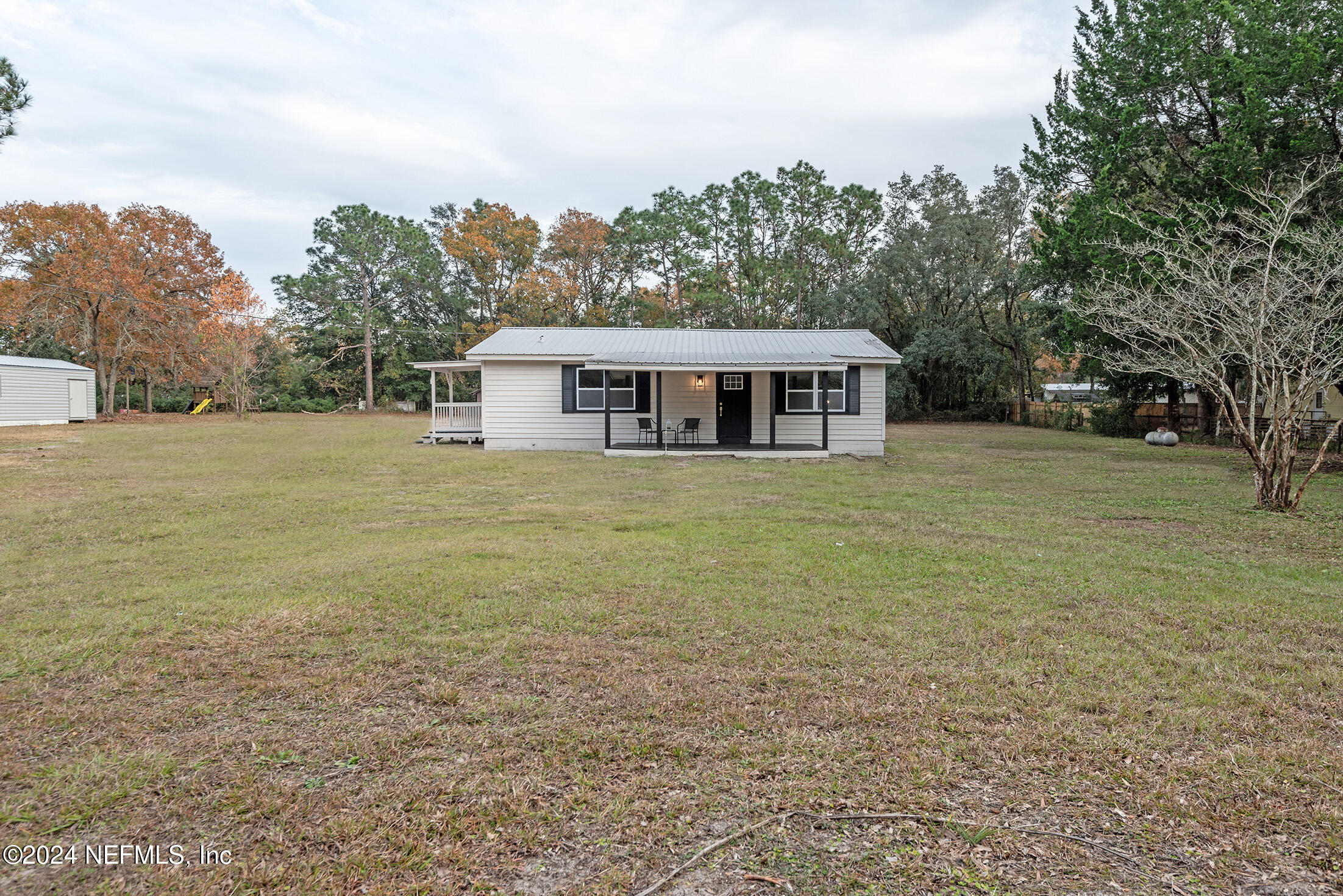 a view of a house with a yard and trees