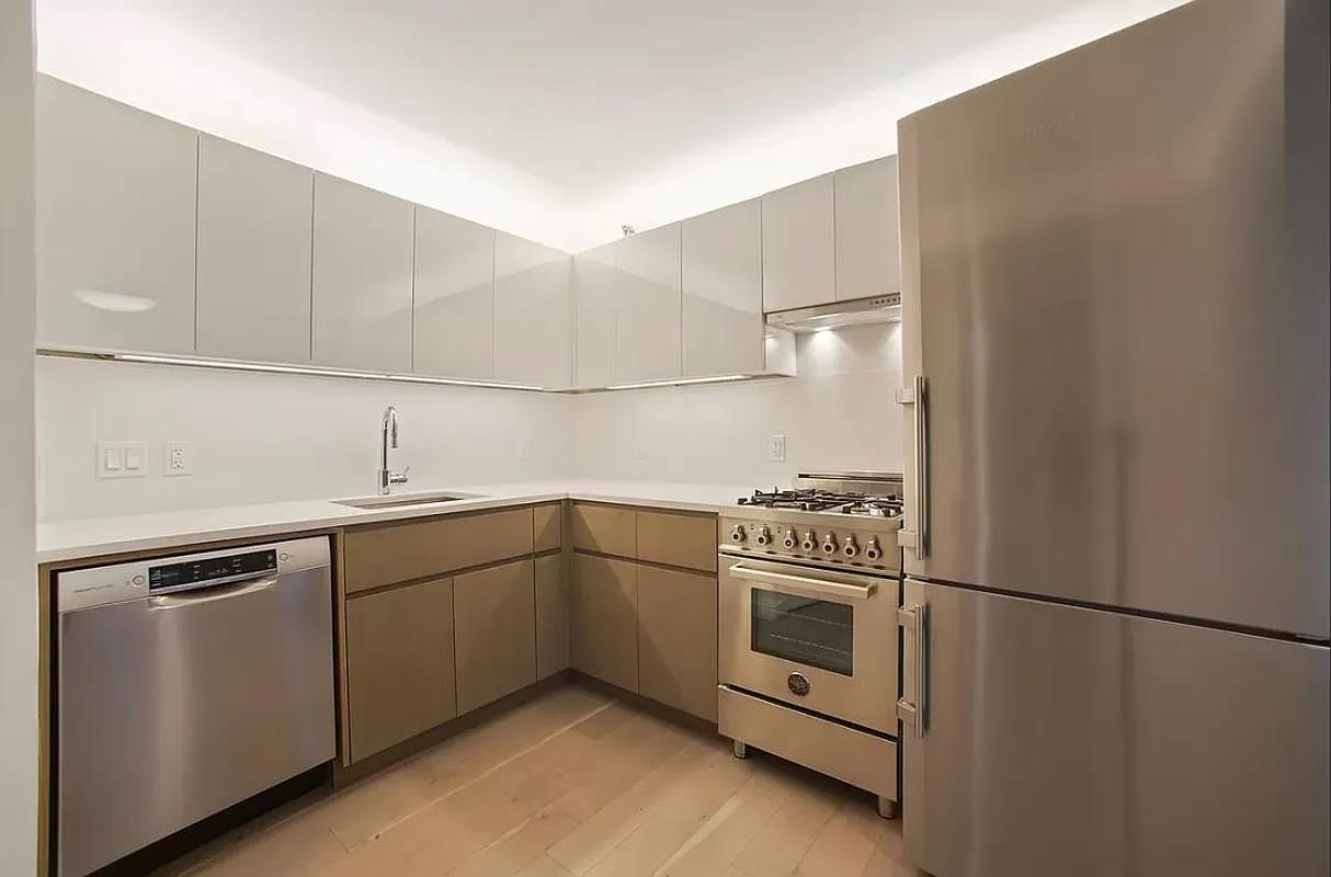 a kitchen with a stove and white cabinets