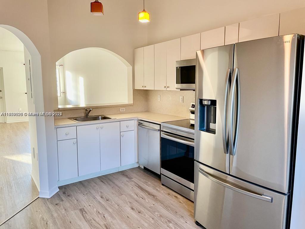 a kitchen with stainless steel appliances a refrigerator sink and microwave