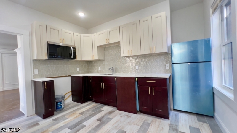 a kitchen with a refrigerator and a stove top oven