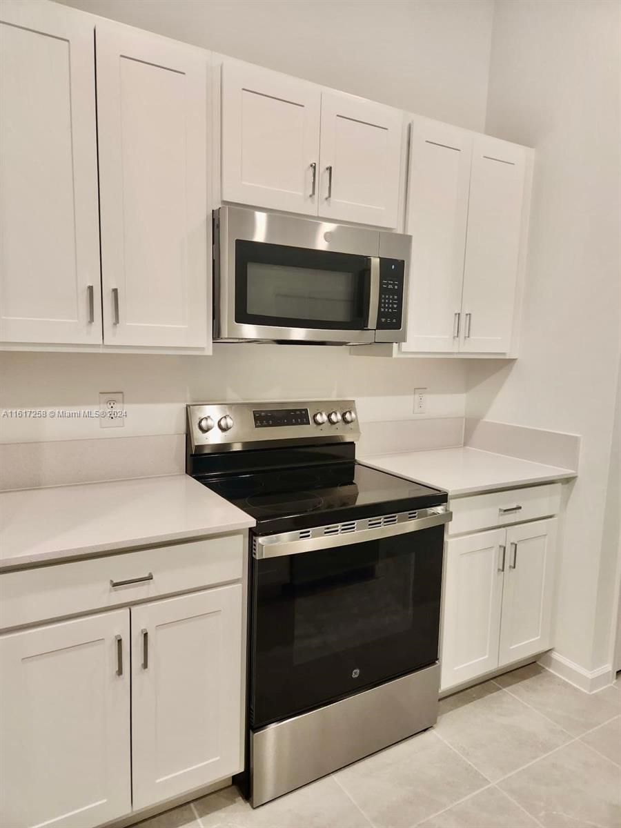 a kitchen with white cabinets and stainless steel appliances