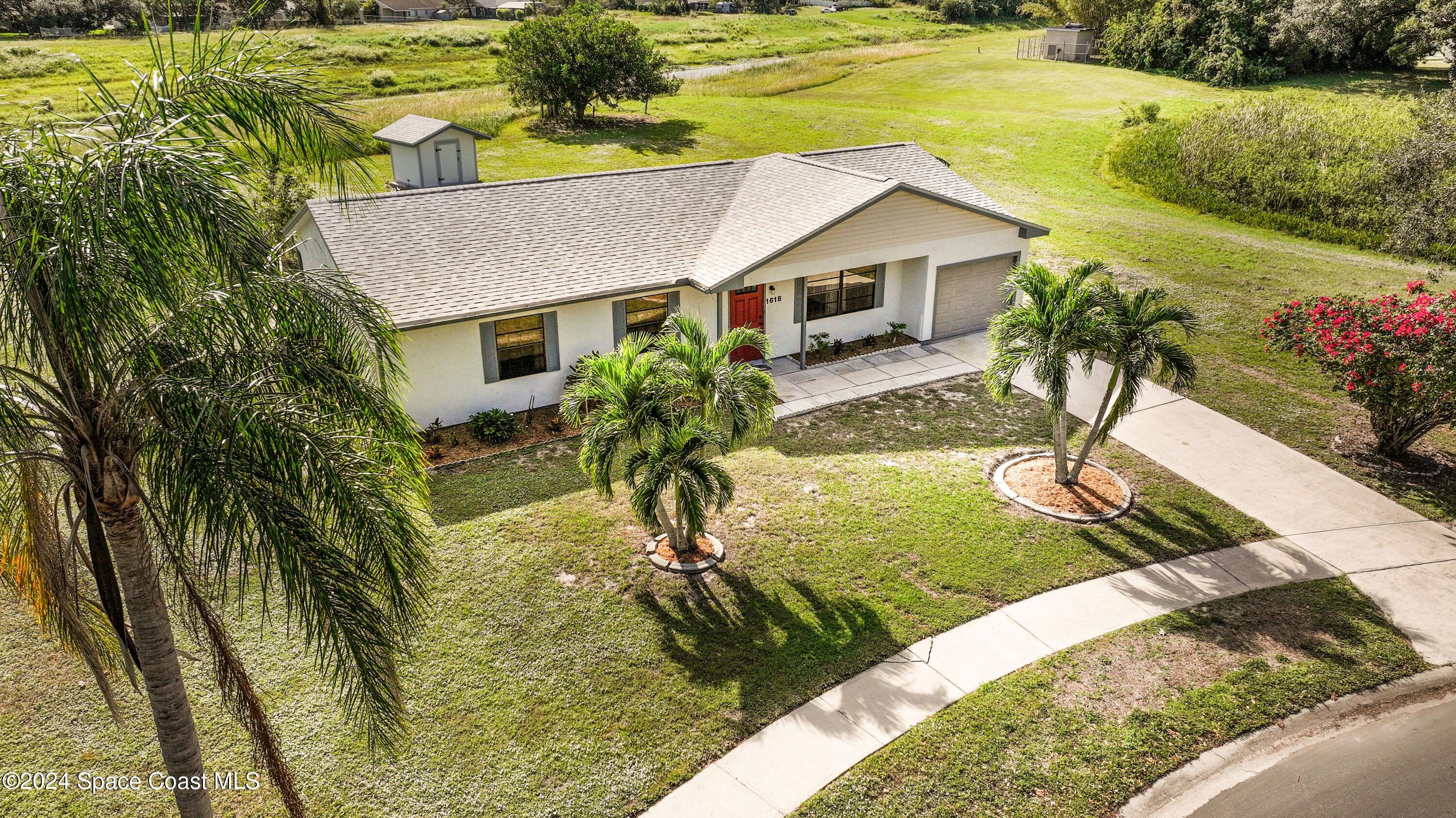 a aerial view of a house with a yard table and chairs