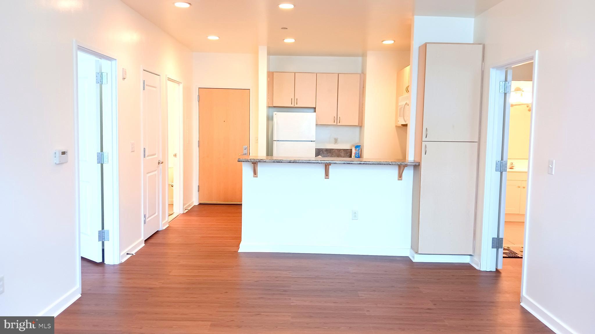 a view of a kitchen with a refrigerator and a stove top oven