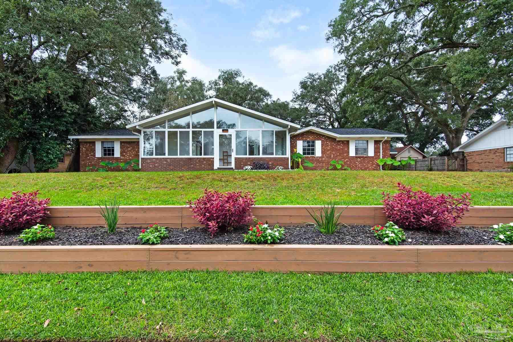 a front view of a house with a yard and outdoor seating