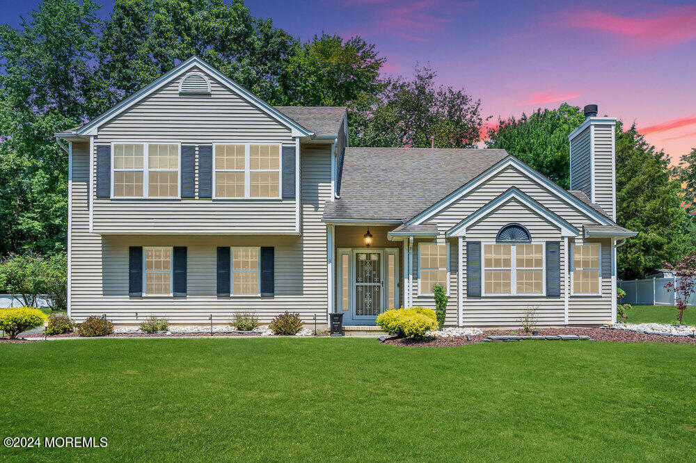 a front view of a house with a yard and trees