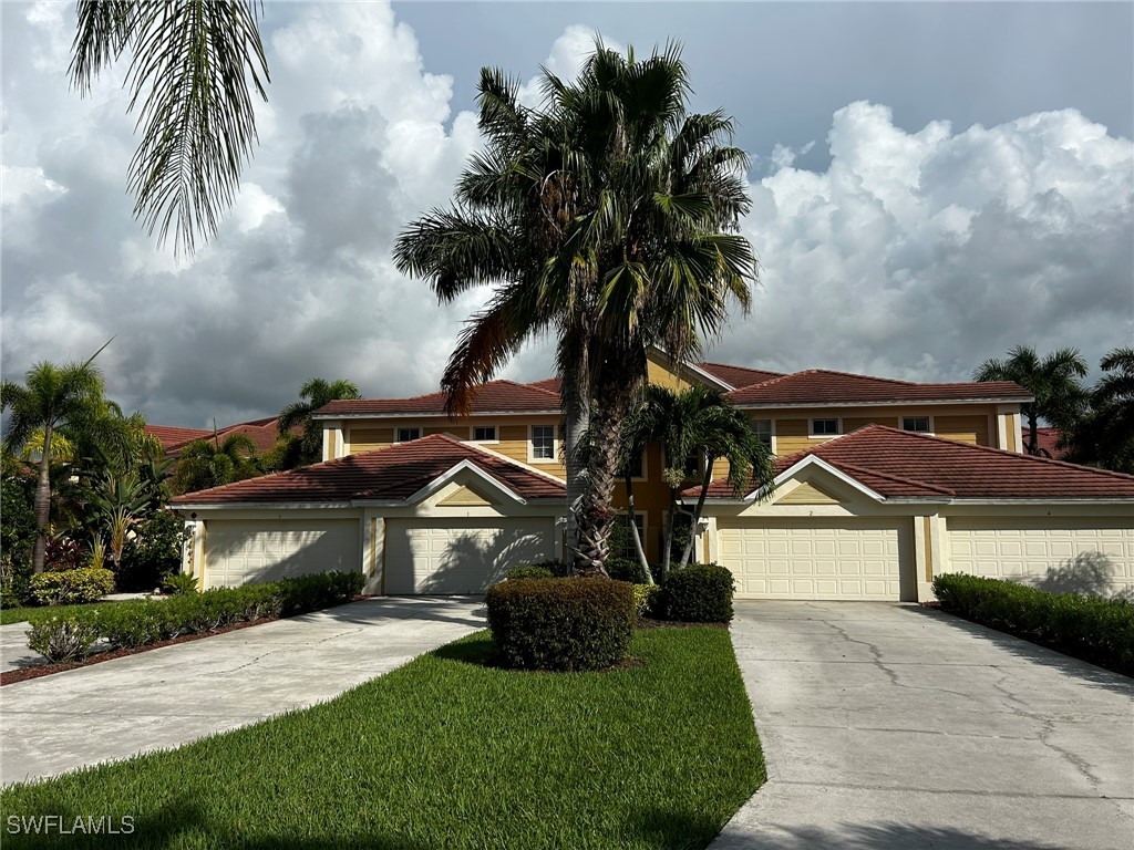 a front view of a house with yard and sign board