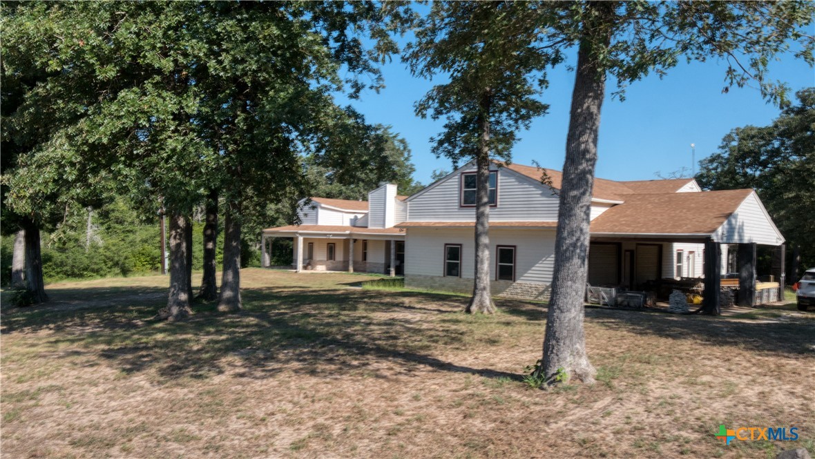 a front view of a house with a yard tree and outdoor seating