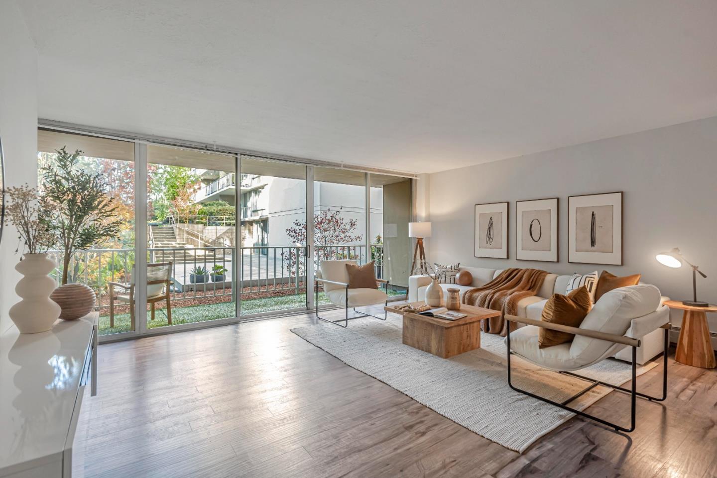 a living room with furniture and a large window with balcony view