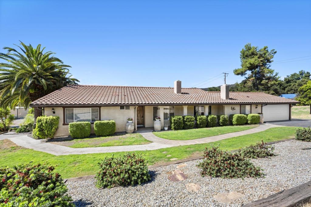 a front view of a house with a yard and potted plants