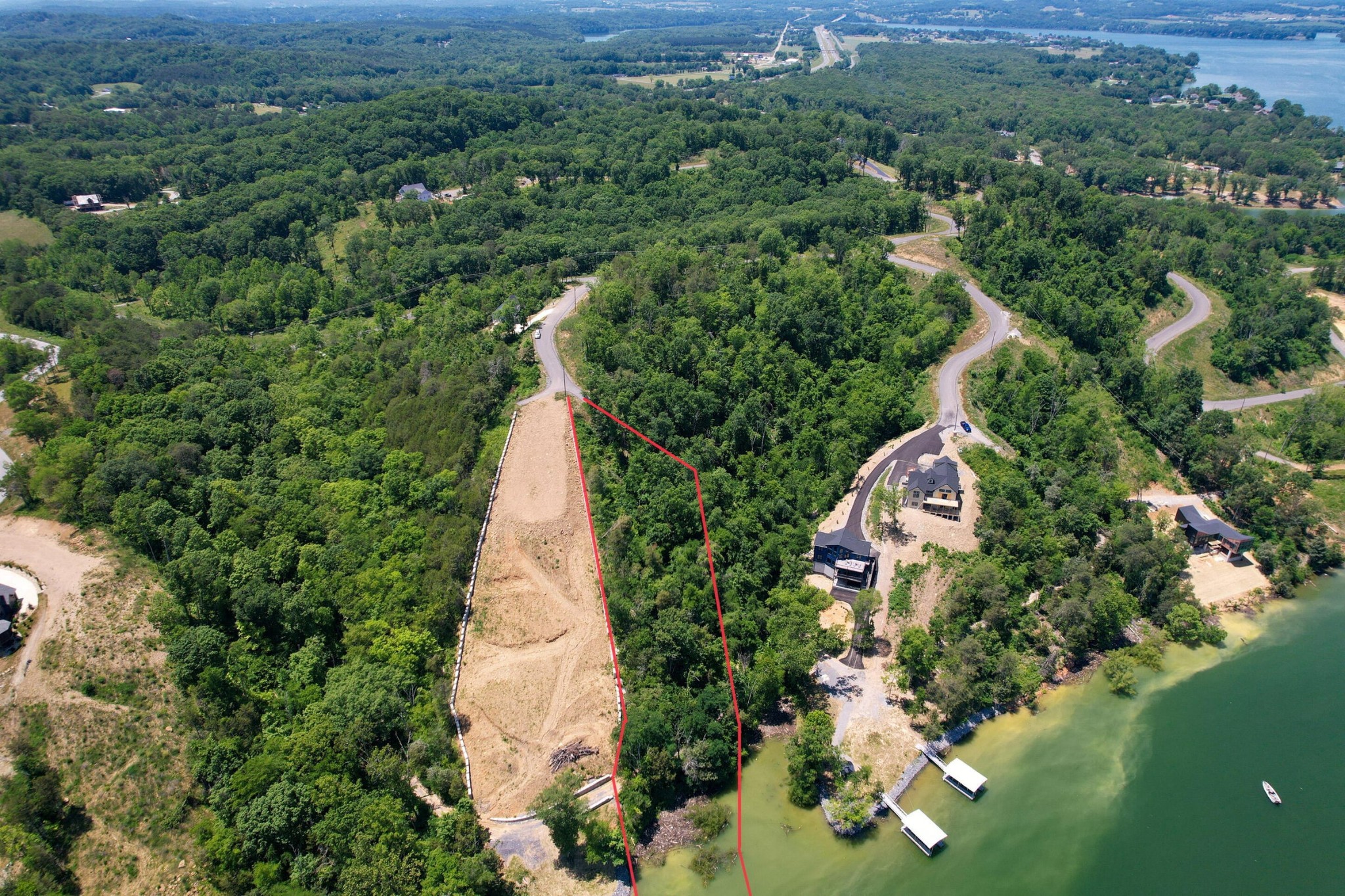 an aerial view of a house with a yard and lake view