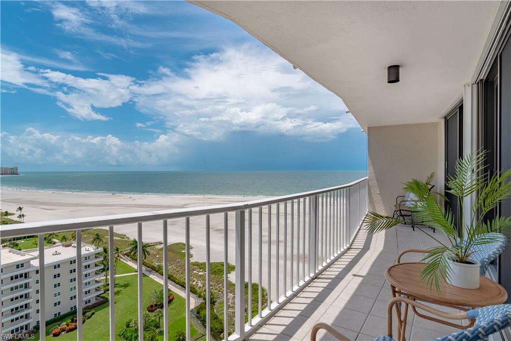 Balcony featuring a water view and a view of the beach