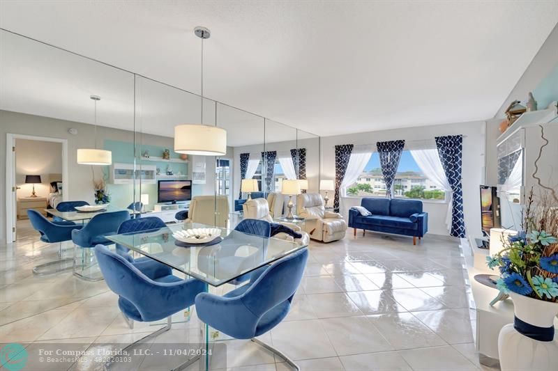 a view of a dining room and livingroom furniture wooden floor a rug and a chandelier