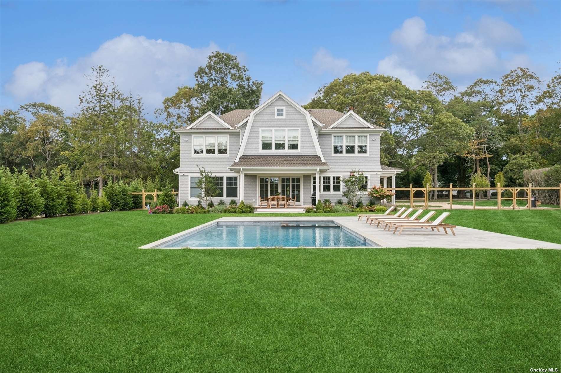 a view of house with a big yard and large trees