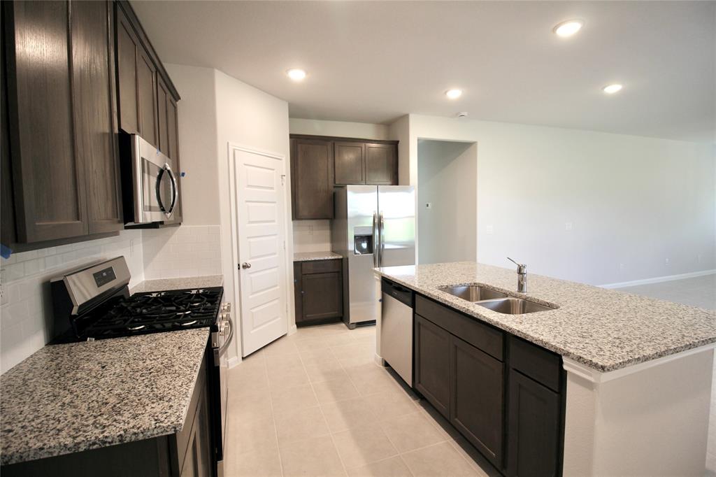 a kitchen with stainless steel appliances granite countertop a sink stove and refrigerator