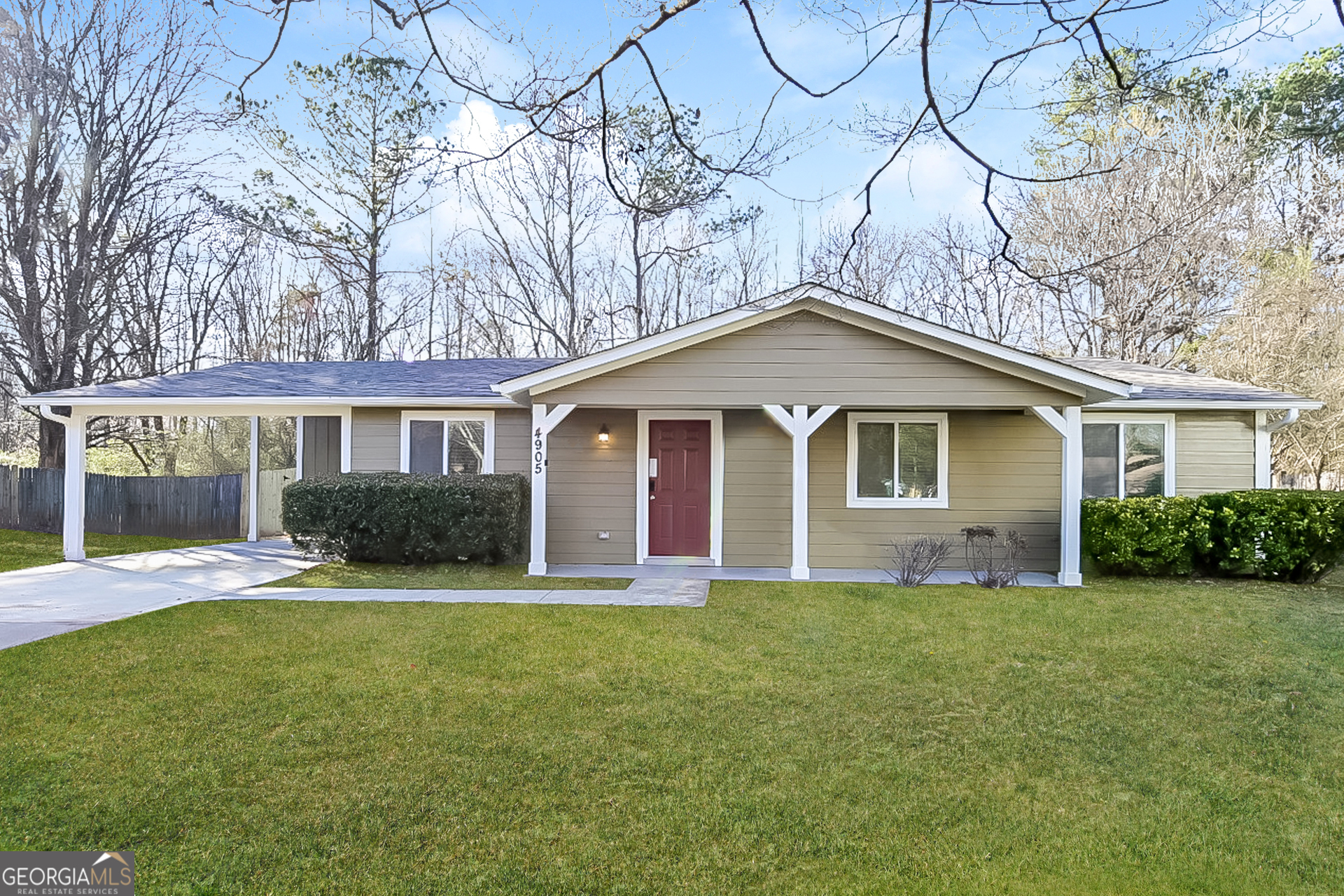 a front view of a house with a yard and trees