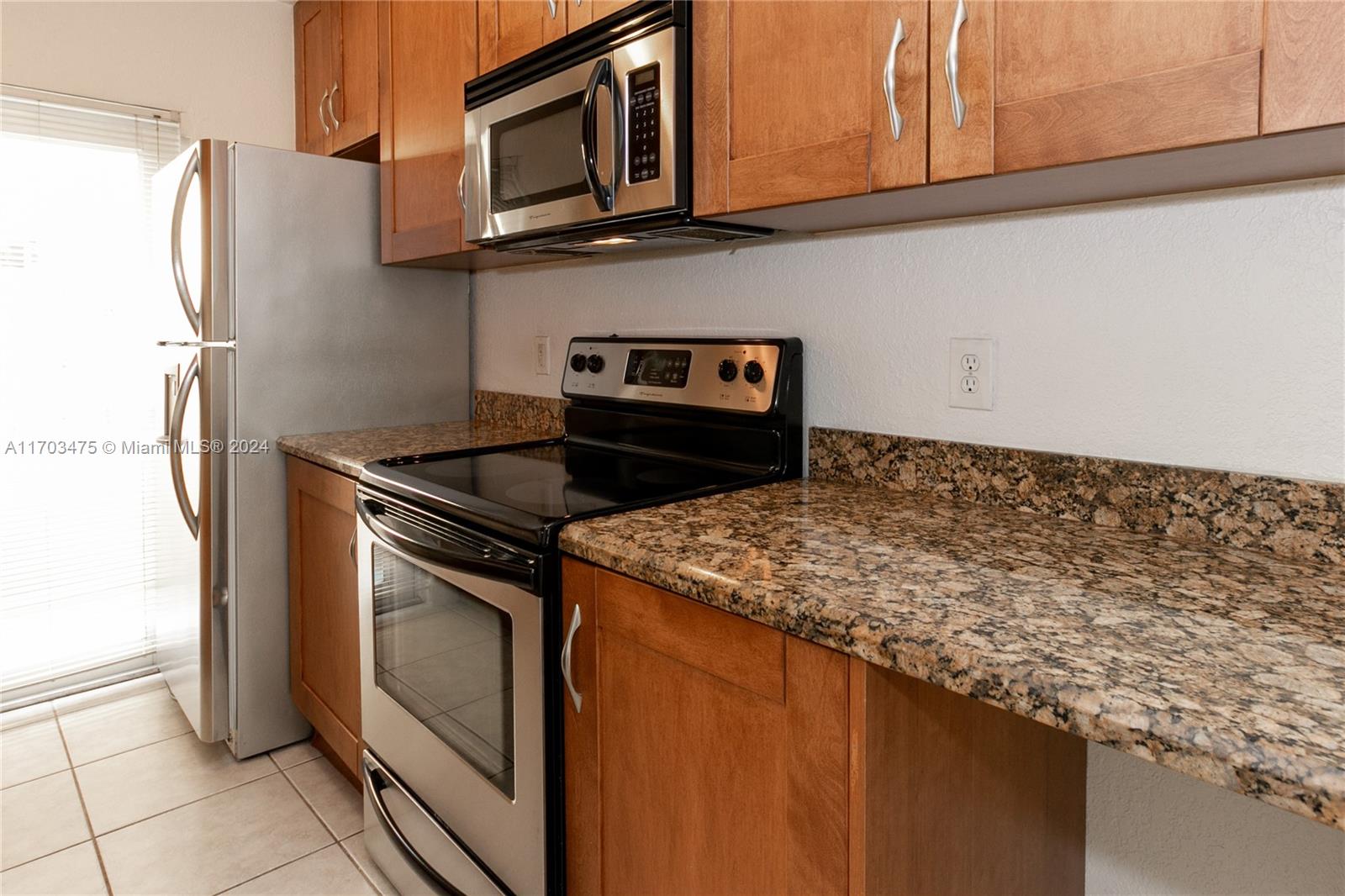 a kitchen with granite countertop cabinets stainless steel appliances and a counter space