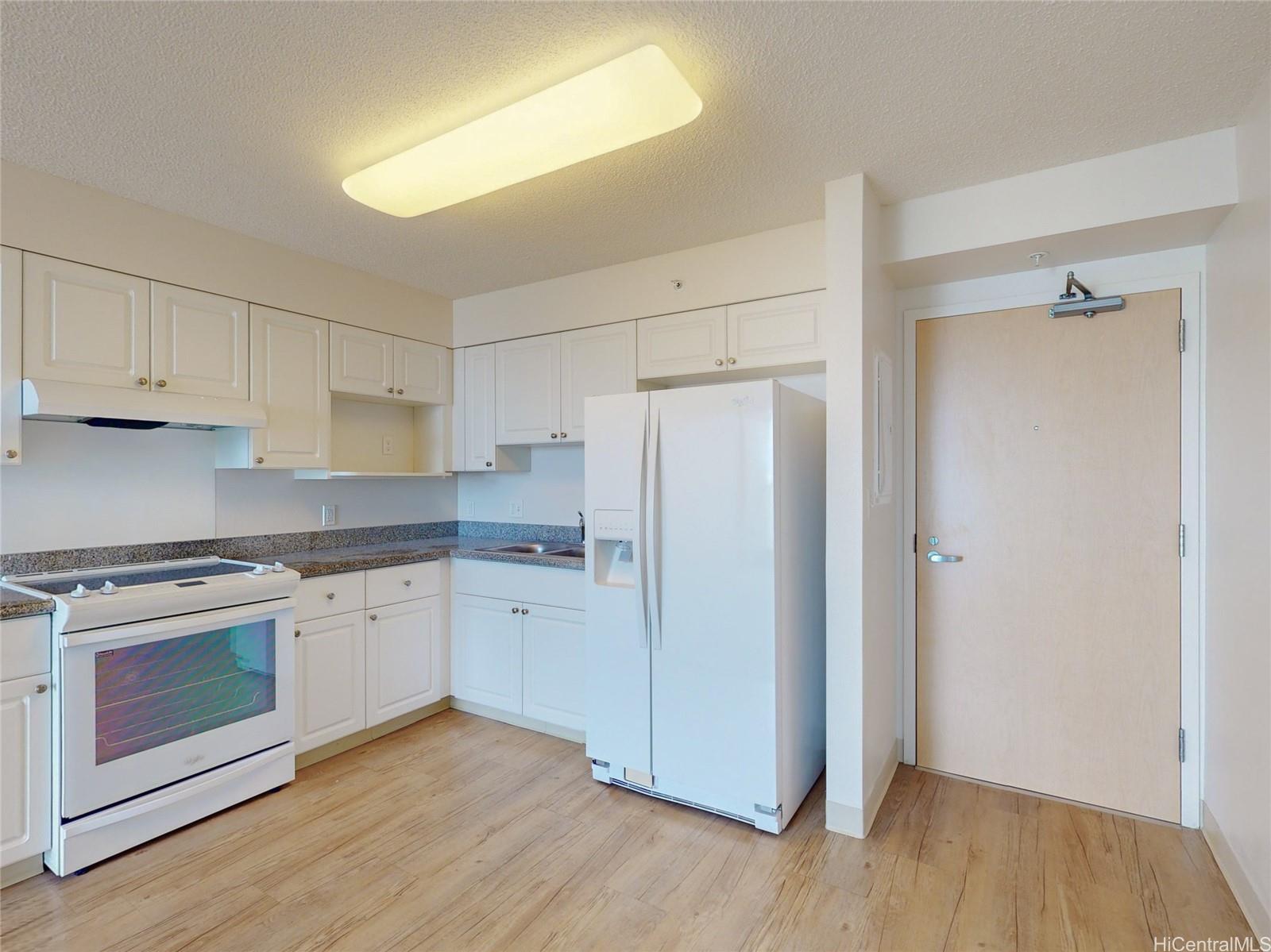 a kitchen with granite countertop white cabinets and white appliances