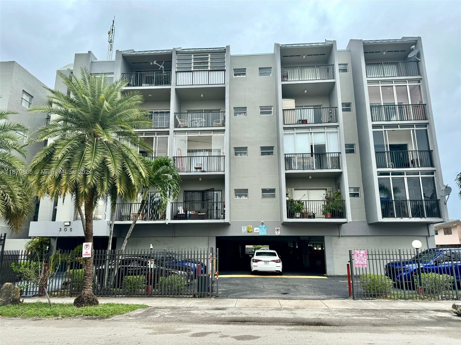 a front view of a building with streets and trees