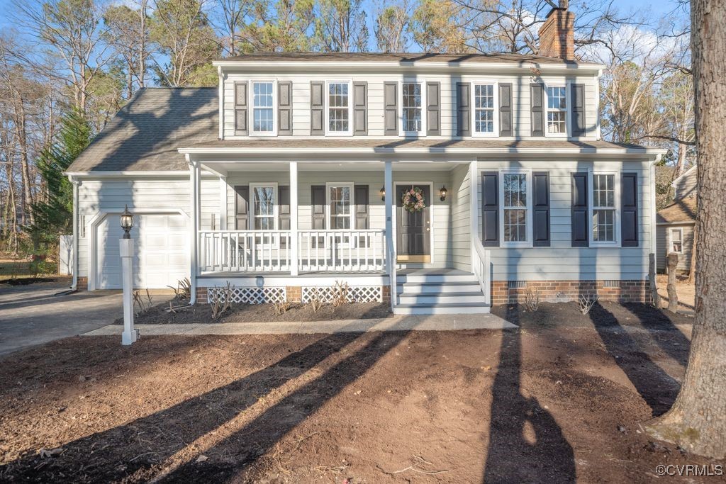 Traditional home with a front porch and  garage